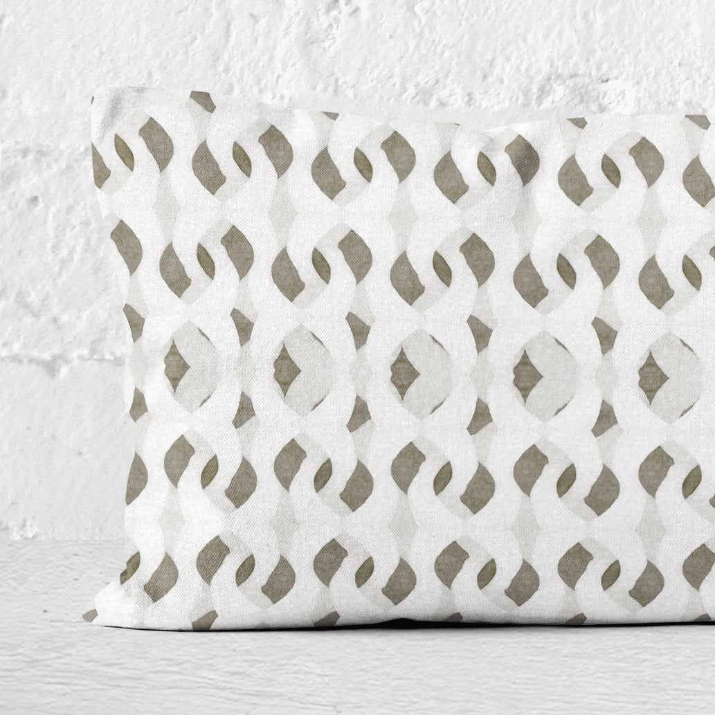 Detail of a rectangular lumbar pillow featuring an abstract hand-painted pattern in warm white, grey, and beige tones.