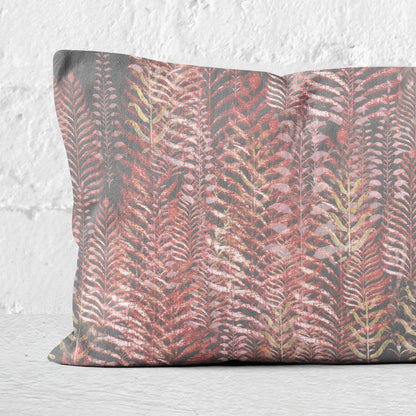 Details of a 12 x 24 inch lumbar pillow featuring feather block print in pink and gray tones.