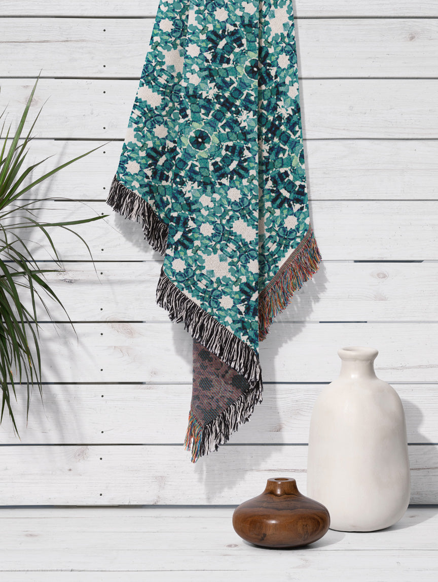 Hanging cotton woven throw blanket featuring a teal hand-painted pattern